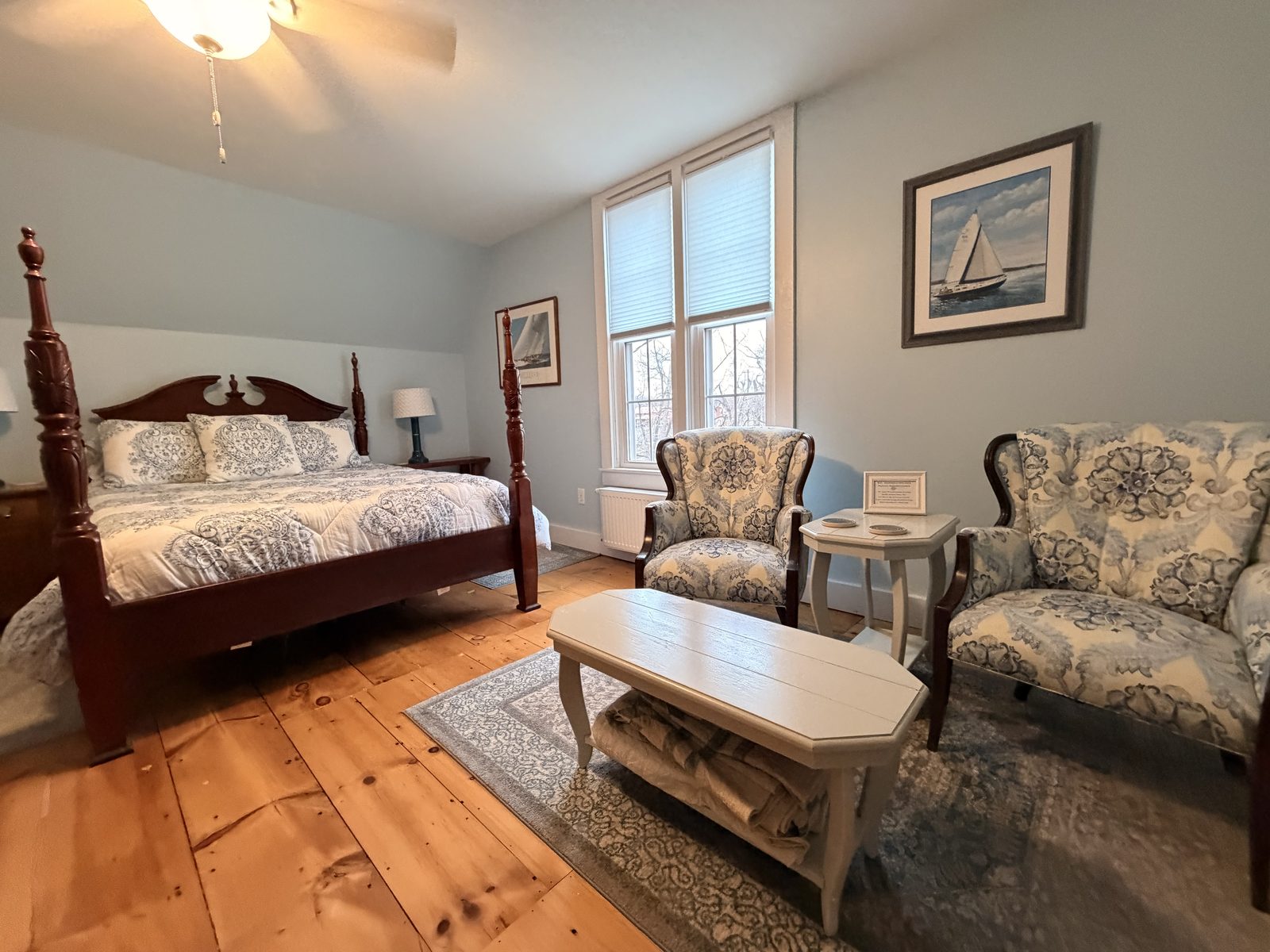 Happy Harvest Farmhouse Blue Room with cherry four-poster bed, wide-plank floors and sailboat art