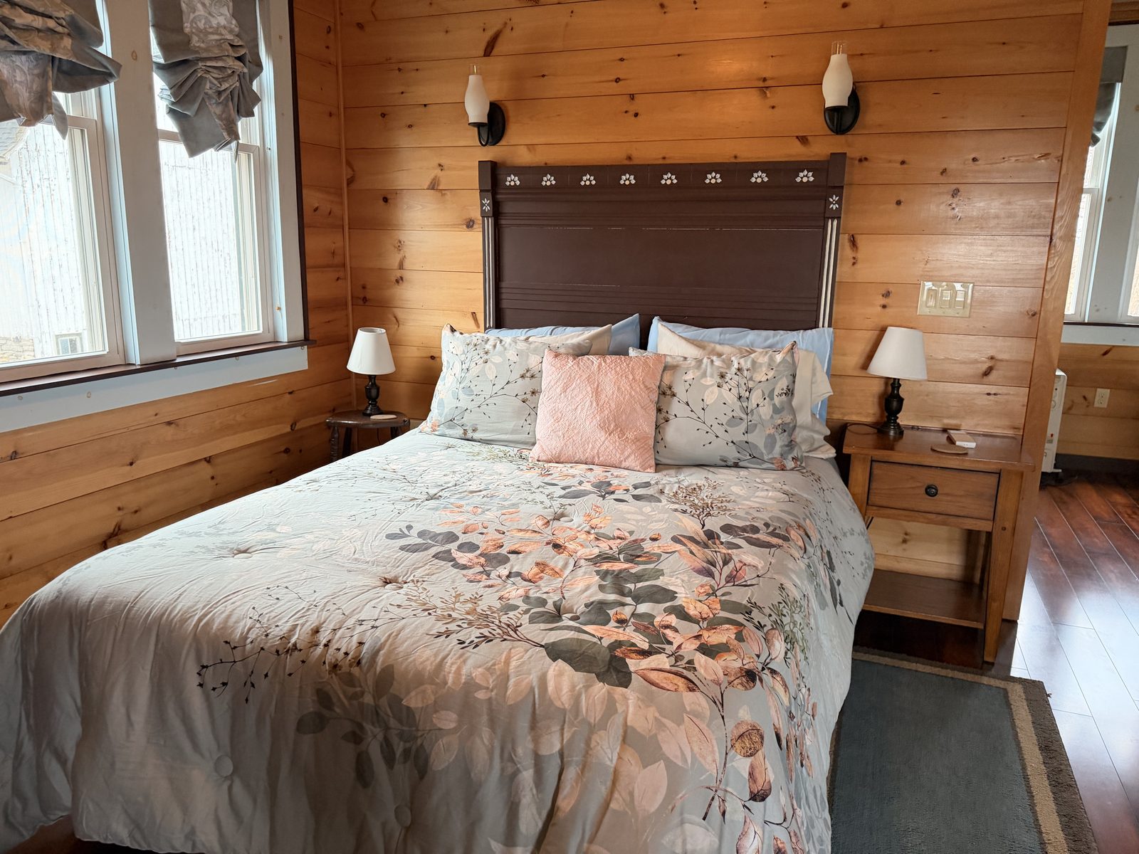 Fruit Packing House bedroom with queen bed, carved wood headboard and pine plank walls
