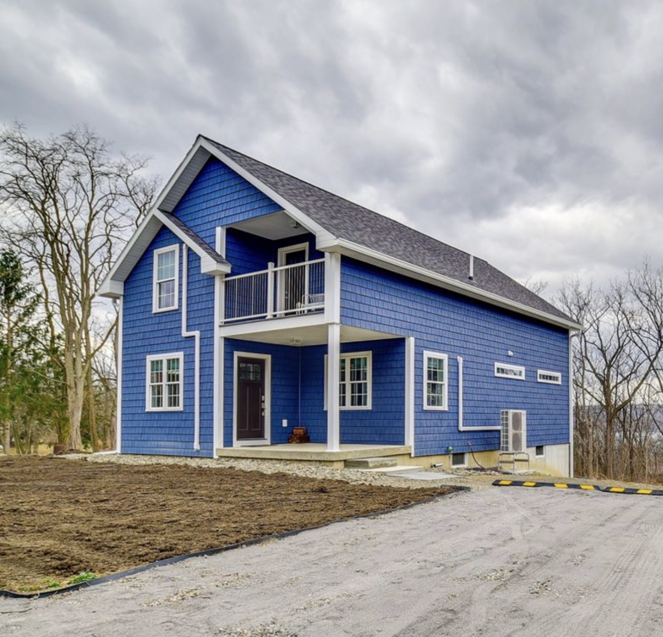 414 Station Guest House exterior — blue shingled two-story building with covered balcony and private entrance