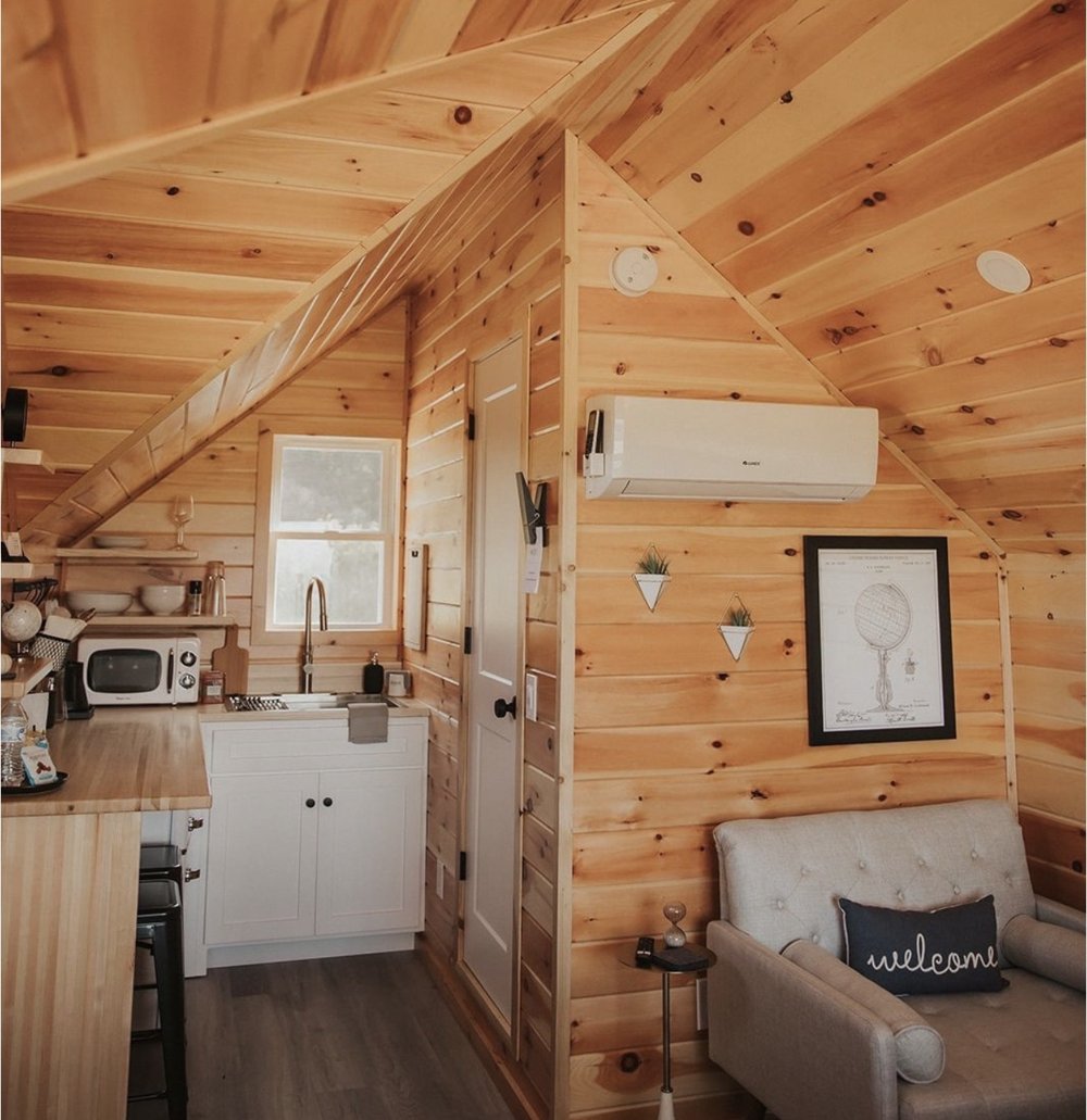 Inside a FLX micro-cabin: kitchenette, knotty pine walls and seating