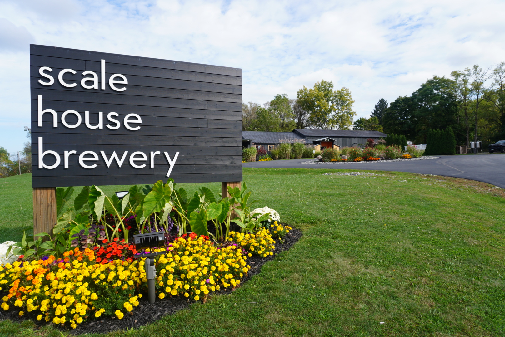 Scale House Brewery sign with flower garden