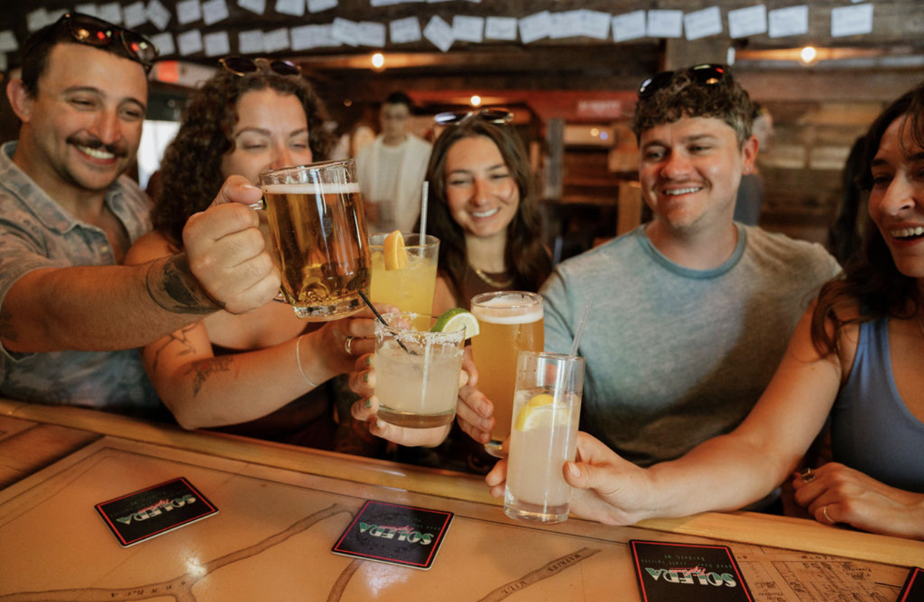 Friends cheersing at Solera Tap House