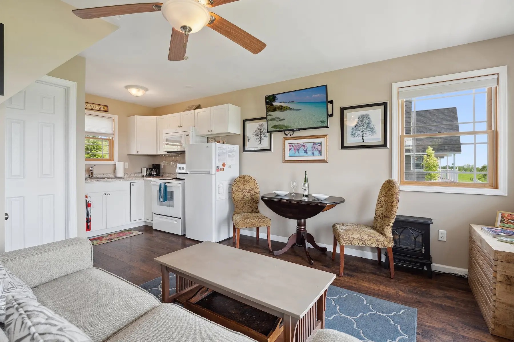 Villa dining nook with table for four, corner windows facing Seneca Lake, and a wall-mounted TV